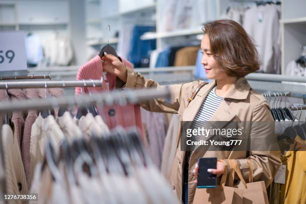 giovani donne asiatiche che acquistano vestiti - abbigliamento da donna foto e immagini stock
