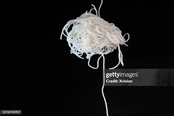 round rice noodle flying in mid air captured with high speed sync. - rice noodles stock pictures, royalty-free photos & images