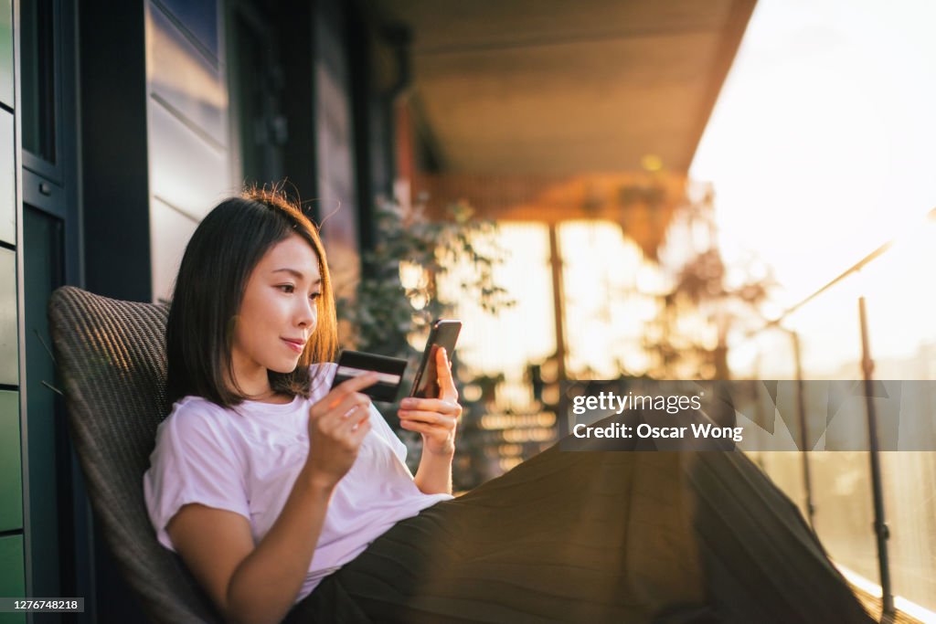 Young Woman Shopping Online With Smart Phone And Credit Card