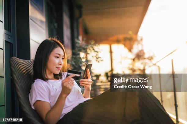 young woman shopping online with smart phone and credit card - beautiful japanese women stock pictures, royalty-free photos & images