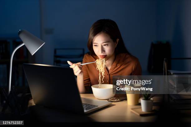 woman eats instant noodles - instant noodles stock pictures, royalty-free photos & images