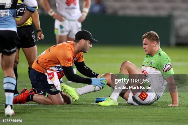 Ryan Sutton of the Raiders is attended to by a trainer after an injury during the round 20 NRL match between the Cronulla Sharks and the Canberra...