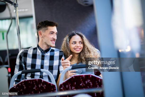 het jonge paar geniet in openbare busrit - tiener koppel stockfoto's en -beelden