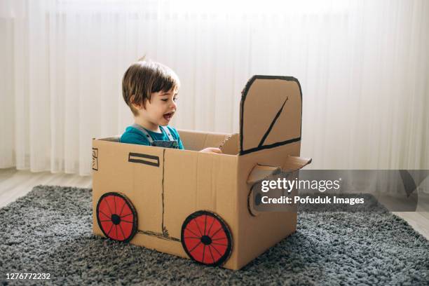 pequeño niño jugar en el coche de cartón - caja cartón fotografías e imágenes de stock