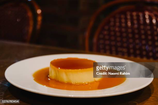 crème caramel dessert served on a white plate on a table - プリン ストックフォトと画像