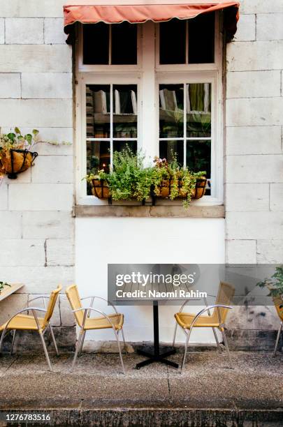 cute dining table and chairs outside a parisian-style cafe in old montreal - vieux montréal stock pictures, royalty-free photos & images