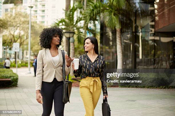 african-american and hispanic businesswomen walking outdoors - miami business imagens e fotografias de stock