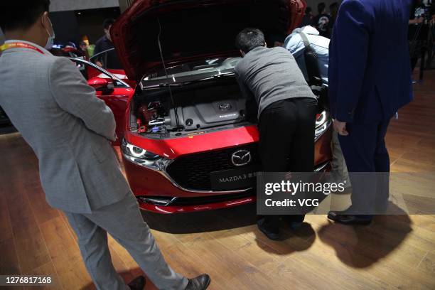 Visitors look at a Mazda 3 Axela car during 2020 Beijing International Automotive Exhibition at China International Exhibition Center on September...