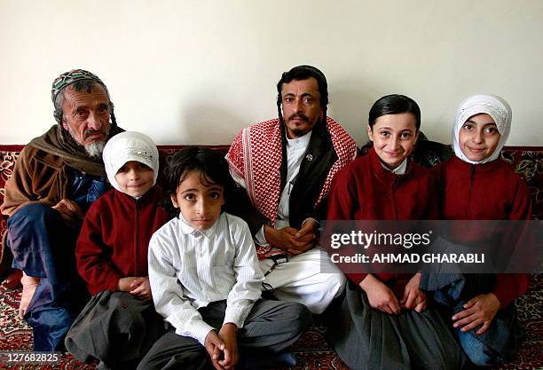 Yemeni Jewish Rabbi Yahia Yussef Mussa , sporting a chequerred Keffiya, poses for a picture with his father, Rabbi Yussef, his daughters and other...