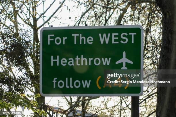a sign pointing out the west, heathrow airport - london, england - heathrow airport fotografías e imágenes de stock