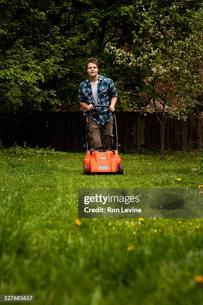 teen boy mowing lawn in suburban backyard - cutting grass stock pictures, royalty-free photos & images