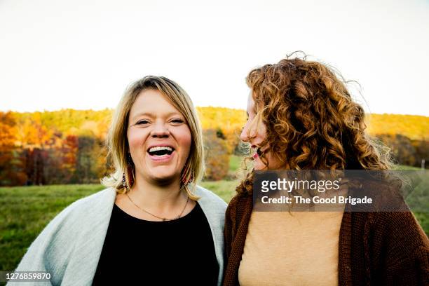 portrait of  cheerful female friends standing in field - adults standing side by side stock pictures, royalty-free photos & images