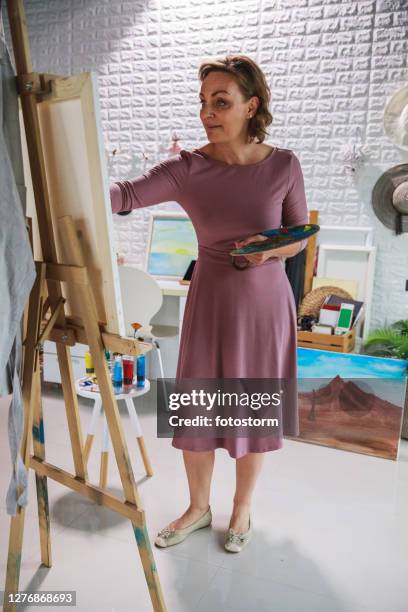 artist focusing while adding details on her painting - canvas easel isolated stock pictures, royalty-free photos & images