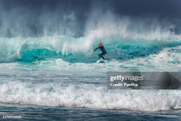 frau surfen auf wellen in teneriffa, playa de las americas, spanien - playa de las americas stock-fotos und bilder