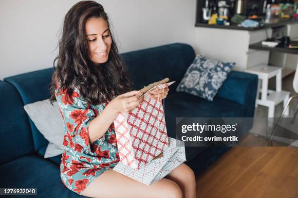 woman opening gift box and reading greeting cards at home - receiving card stock pictures, royalty-free photos & images