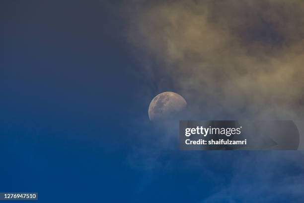 a crescent moon stands out on a blue sky at sunset. - eid sky imagens e fotografias de stock