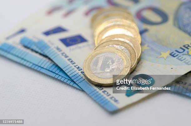 euro coins on top of 20 euro banknotes - one euro coin stock pictures, royalty-free photos & images