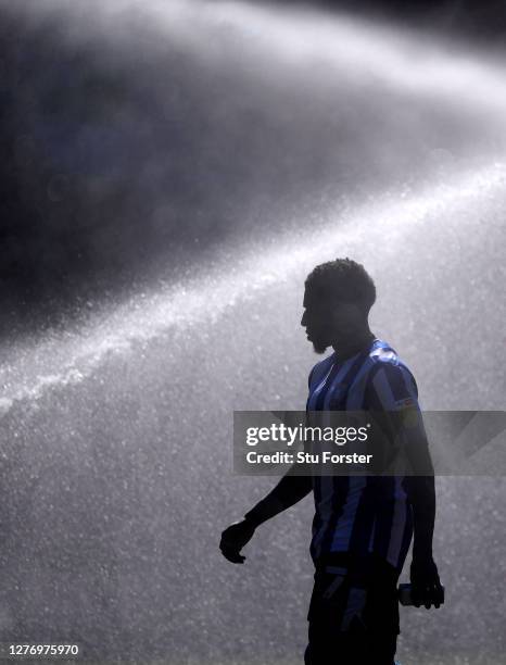 Sheffield Wednesday player Kadeem Harris takes to the field as the pitch sprinklers spray the pitch before the Sky Bet Championship match between...