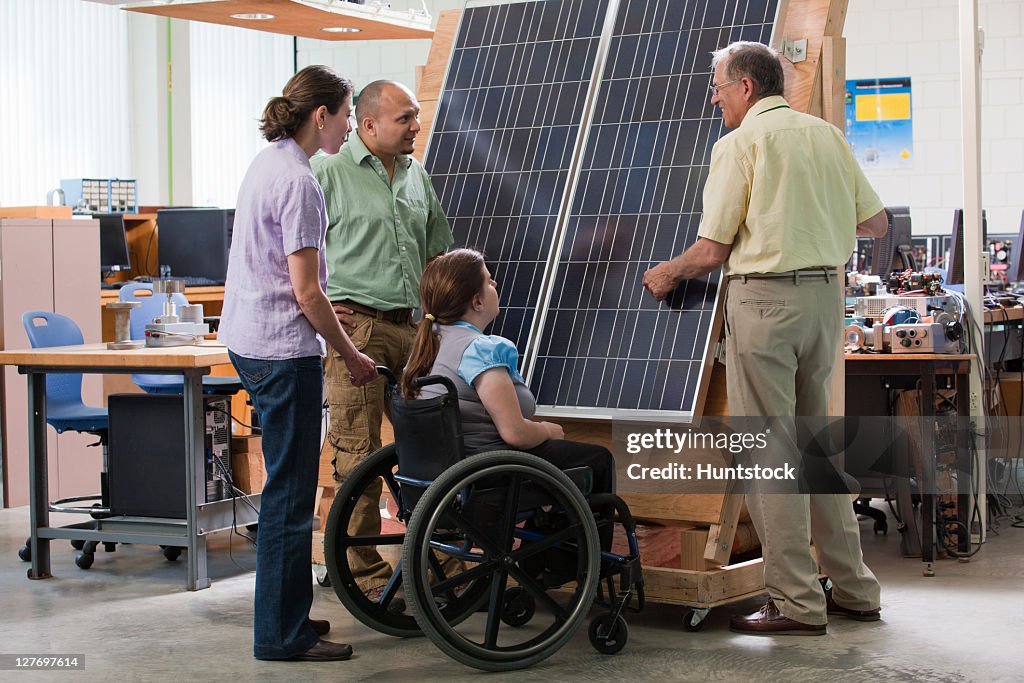 Professor discussing serial connection of photo cells in photovoltaic panel
