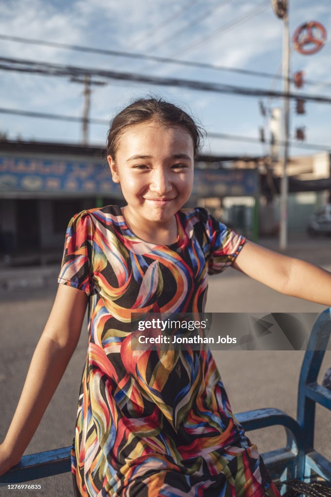 Asian girl with a smile leaning on the railing