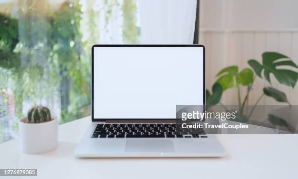 laptop computer blank white screen on table in cafe background. laptop with blank screen on table of coffee shop blur background. - desk stock pictures, royalty-free photos & images