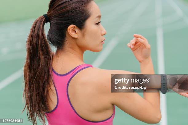 young female athlete warming up before sports training - all weather running track stock pictures, royalty-free photos & images