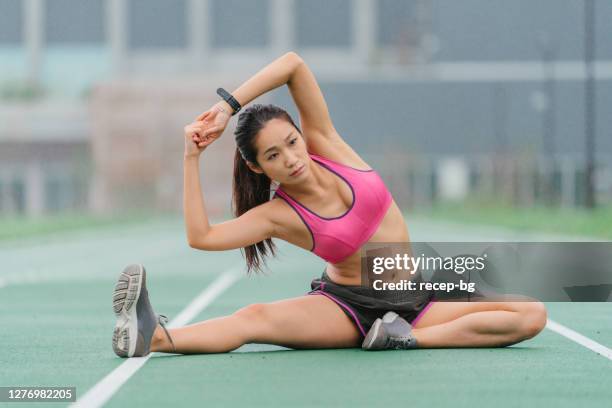 joven atleta que se calienta antes del entrenamiento deportivo - all weather running track fotografías e imágenes de stock