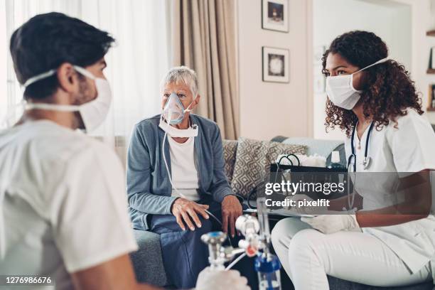 nothilfe-praktizierende besuchen eine seniorin - atemhilfe stock-fotos und bilder