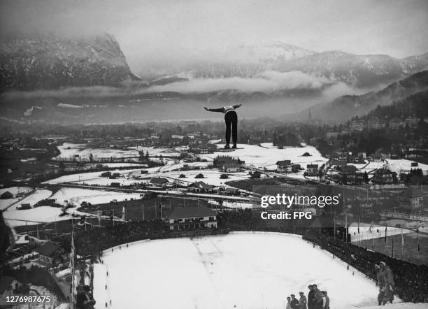 General view from the Grosse Olympiaschanze showing a ski jumper in flight during a trial run for Olympiaschanze ahead of the 1936 Winter Olympics in...