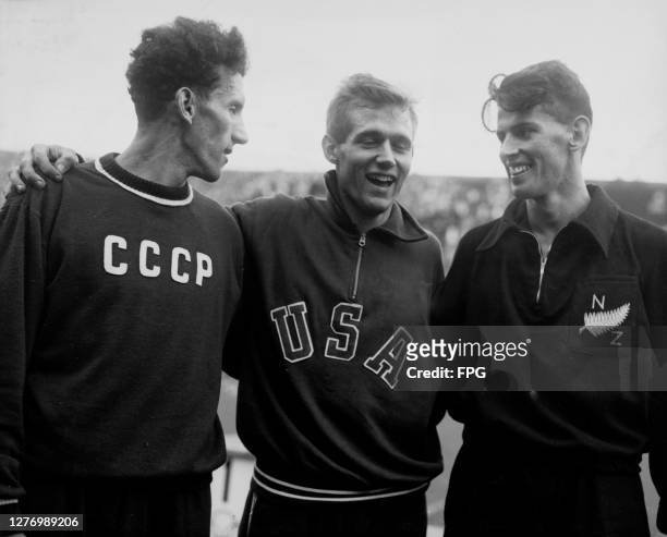 Soviet athlete Yuriy Lituyev , American athlete Charles Moore, and New Zealand athlete John Holland , each wearing their nation's tracksuit, after...