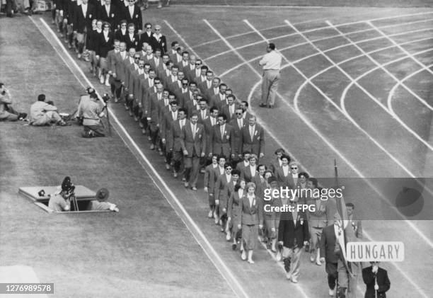 Photographers on the bank beside the running track as the Hungarian team make their entrance, following the flagbearer, at the closing ceremony for...