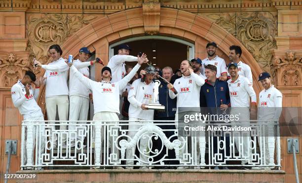 Essex captain Tom Westley holds the Bob Willis Trophy as he celebrates on the Pavilion balcony with his teammates and head coach Anthony McGrath...