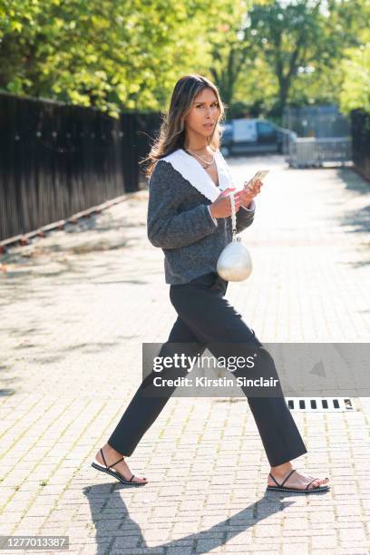 Model, writer and presenter Isabella Charlotta Poppius wears a Ganni shirt, cardigan, trousers, Essen sandals, Simone Rocha bag during LFW September...