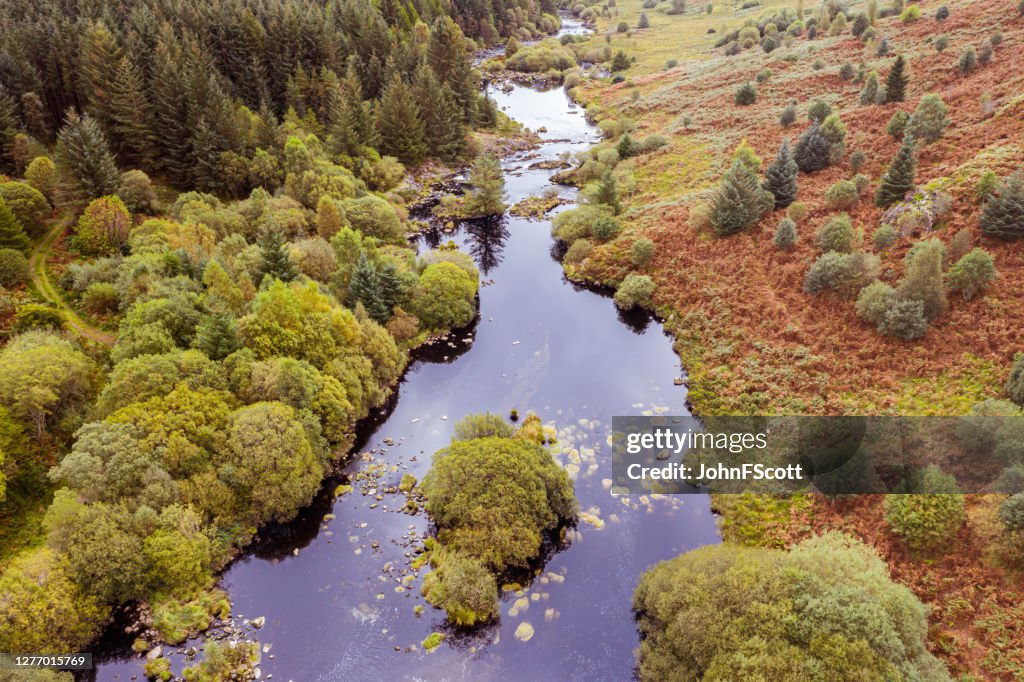 De luchtmening van een rivier die door een gebied van landelijk Schotland stroomt