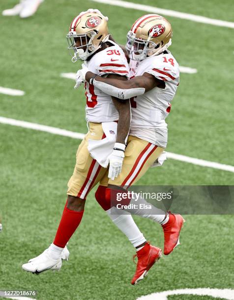 Jeff Wilson Jr. #30 of the San Francisco 49ers is congratulated by teammate Mohamed Sanu after Wilson Jr. Scored a touchdown in the fourth quarter...