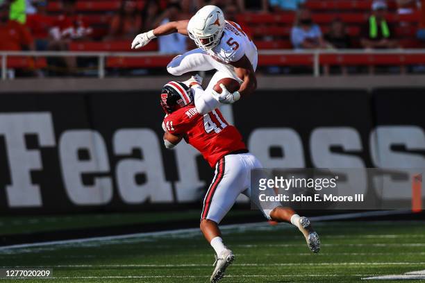 Running back Bijan Robinson of the Texas Longhorns is upended by linebacker Jacob Morgenstern of the Texas Tech Red Raiders during the second half of...