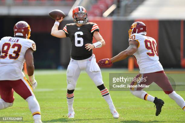 Quarterback Baker Mayfield of the Cleveland Browns passes while under pressure from defensive tackle Jonathan Allen and defensive end Montez Sweat of...
