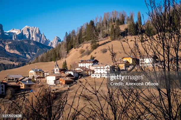 beautiful autumn alpine landscape with church and alpine houses. soraga. moena. bolzano province. south tyrol. italy - soraga stock pictures, royalty-free photos & images