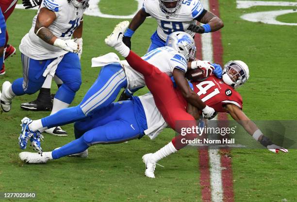 Kenyan Drake of the Arizona Cardinals is tackled by Da'Shawn Hand and Tracy Walker of the Detroit Lions during the first quarter at State Farm...