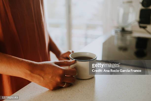 a young woman enjoying of a mug of tea at home - traditional ceremony stock pictures, royalty-free photos & images