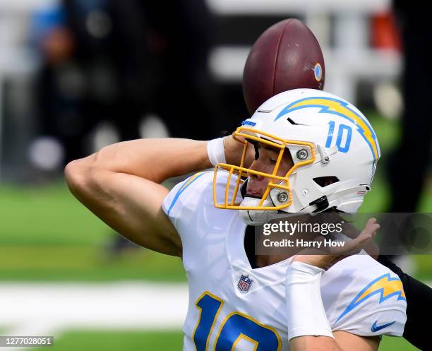 Justin Herbert of the Los Angeles Chargers fumbles during the first quarter against the Carolina Panthers at SoFi Stadium on September 27, 2020 in...