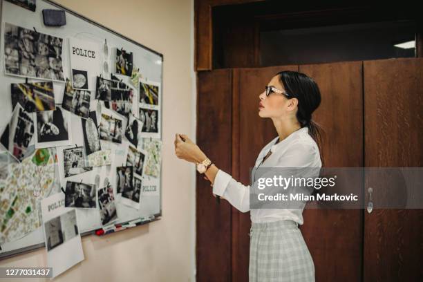 the lady detective is looking for clues about the case of a serious crime - - the hard work of a detective in the office - the detective in the office is working to gather evidence and clues in finding the killer - fbi files stock pictures, royalty-free photos & images