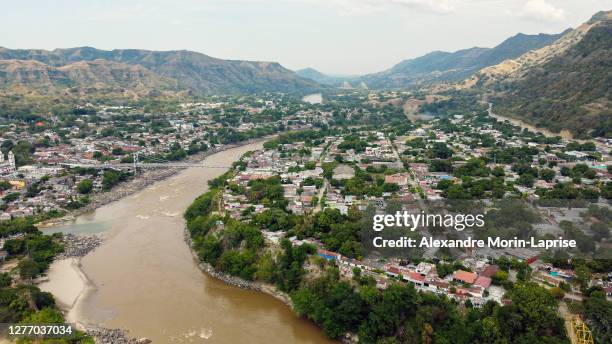 hanging bridge that passes over a river surrounded by a lot of vegetation in honda, tolima / colombia - マグダレーナ ストックフォトと画像