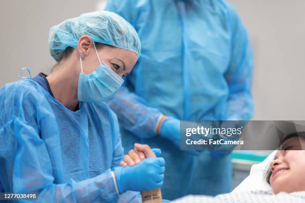 surgeon showing support, holding hand of pregnant patient - surgeon patient stock pictures, royalty-free photos & images