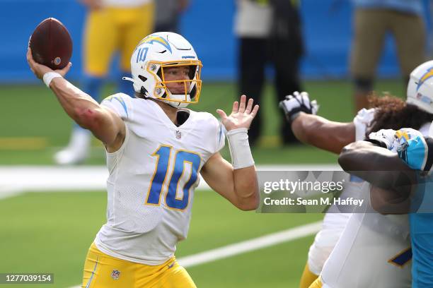 Justin Herbert of the Los Angeles Chargers passes the ball under pressure during the second half of a game against the Carolina Panthers at SoFi...