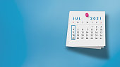 2021 July Calendar on Note Pad Against Blue Background