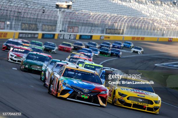 Kyle Busch, driver of the M&M's Toyota, and Joey Logano, driver of the Pennzoil Ford, lead the field during the NASCAR Cup Series South Point 400 at...