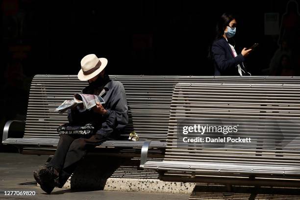 Person reads the newspaper along Bourke Street Mall on September 28, 2020 in Melbourne, Australia. Coronavirus restrictions have eased across...