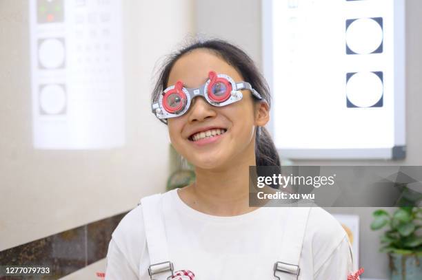 girl with eyesight check - hyperopie stock-fotos und bilder
