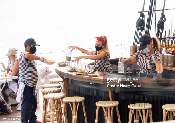 Bartenders work on the Grand Banks boat restaurant at Pier 25 as the city continues Phase 4 of re-opening following restrictions imposed to slow the...